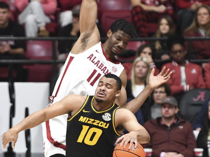 Jan 16, 2024; Tuscaloosa, Alabama, USA; Missouri guard Nick Honor (10) dribbles away from Alabama forward Mohamed Wague (11) after they made contact in their game at Coleman Coliseum. Mandatory Credit: Gary Cosby Jr.-USA TODAY Sports