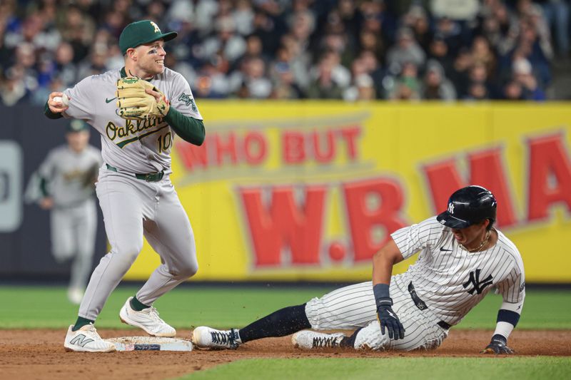 Apr 25, 2024; Bronx, New York, USA; Oakland Athletics shortstop Nick Allen (10) forces out New York Yankees third baseman Oswaldo Cabrera (95) during the fourth inning at Yankee Stadium. Mandatory Credit: Vincent Carchietta-USA TODAY Sports