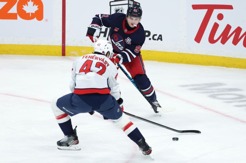 Dec 13, 2025; Winnipeg, Manitoba, CAN; Winnipeg Jets center Cole Perfetti (91) shoots the puck past Washington Capitals defenseman Martin Fehérváry (42) in the second period at Canada Life Centre. Mandatory Credit: James Carey Lauder-Imagn Images