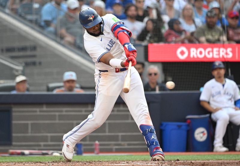 Sep 14, 2024; Toronto, Ontario, CAN;  Toronto Blue Jays first baseman Vladimir Guerrero Jr. (27) hits an RBI single against the St. Louis Cardinals in the seventh inning at Rogers Centre. It was the 500th RBI of his career. Mandatory Credit: Dan Hamilton-Imagn Images