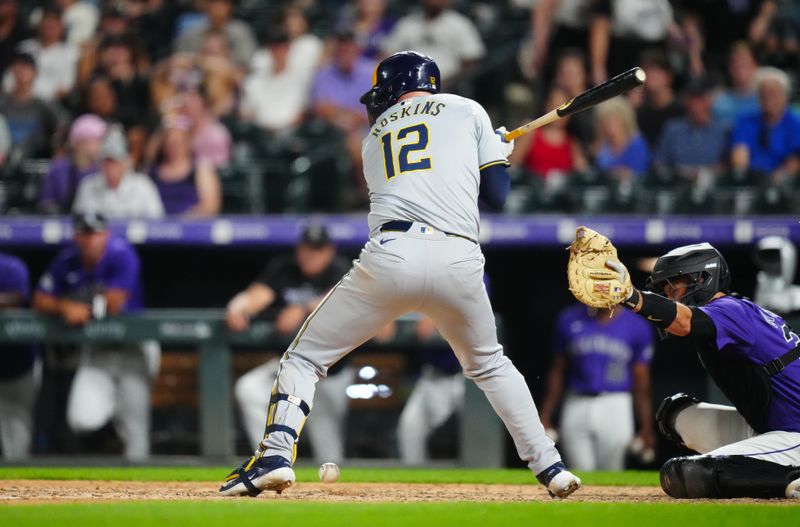 Jul 2, 2024; Denver, Colorado, USA; Milwaukee Brewers first base Rhys Hoskins (12) is hit by a pitch to drive in a run in the ninth inning against the Colorado Rockies at Coors Field. Mandatory Credit: Ron Chenoy-USA TODAY Sports