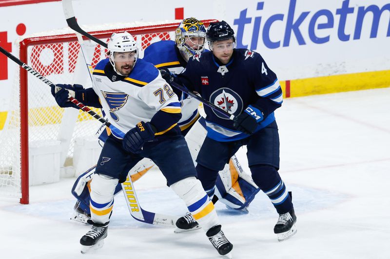 Feb 27, 2024; Winnipeg, Manitoba, CAN; Winnipeg Jets defenseman Neal Pionk (4) jostles for position with St. Louis Blues defenseman Justin Faulk (72) in front of St. Louis Blues goalie Joel Hofer (30) during the third period at Canada Life Centre. Mandatory Credit: Terrence Lee-USA TODAY Sports