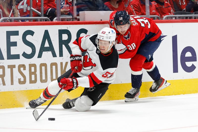 Nov 23, 2024; Washington, District of Columbia, USA; New Jersey Devils left wing Jesper Bratt (63) is tripped while skating with the puck by Washington Capitals defenseman Rasmus Sandin (38) in the second period at Capital One Arena. Mandatory Credit: Geoff Burke-Imagn Images