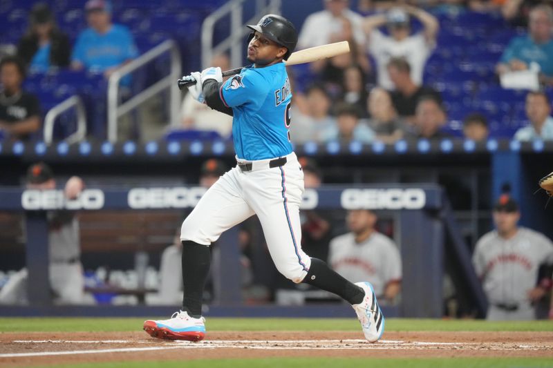 Jun 1, 2025; Miami, Florida, USA;  Miami Marlins second baseman Xavier Edwards (9) hits a double in the first inning against the San Francisco Giants at loanDepot Park. Mandatory Credit: Jim Rassol-Imagn Images