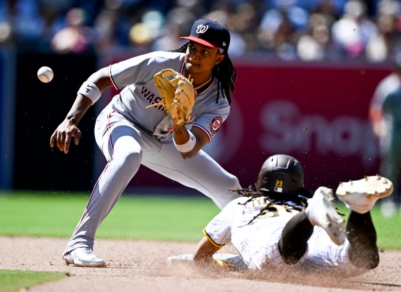 Jun 25, 2025; San Diego, California, USA; San Diego Padres right fielder Fernando Tatis Jr. (23) steals second base ahead of the throw to Washington Nationals shortstop CJ Abrams (5) during the eighth inning at Petco Park. Mandatory Credit: Denis Poroy-Imagn Images