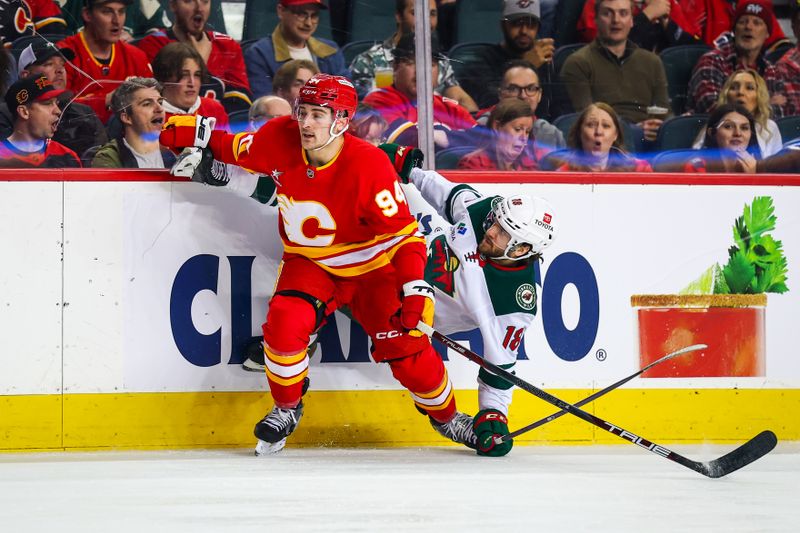 Apr 11, 2025; Calgary, Alberta, CAN; Calgary Flames defenseman Brayden Pachal (94) checks into the boards Minnesota Wild center Vinnie Hinostroza (18) during the first period at Scotiabank Saddledome. Mandatory Credit: Sergei Belski-Imagn Images