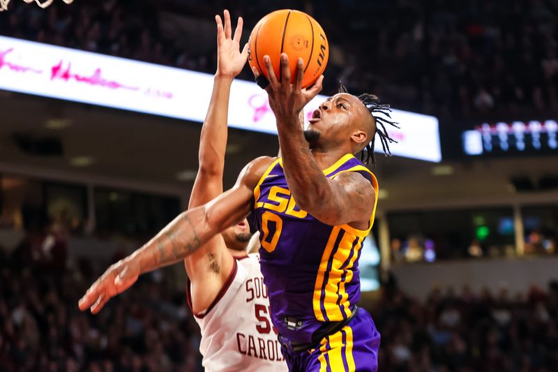 Feb 17, 2024; Columbia, South Carolina, USA; LSU Tigers guard Trae Hannibal (0) drives past South Carolina Gamecocks guard Ta'Lon Cooper (55) in the second half at Colonial Life Arena. Mandatory Credit: Jeff Blake-USA TODAY Sports