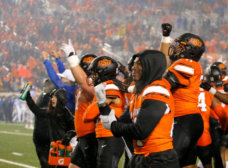 Nov 25, 2023; Stillwater, Oklahoma, USA;  Oklahoma State Cowboys players celebrate following the second overtime against the Brigham Young Cougars at Boone Pickens Stadium. Mandatory Credit: Sarah Phipps-USA TODAY Sports