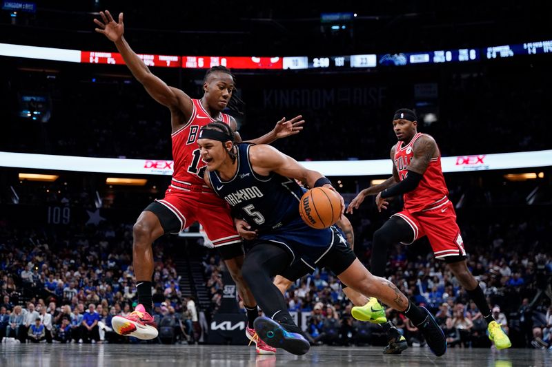 ORLANDO, FLORIDA - APRIL 07: Paolo Banchero #5 of the Orlando Magic dribbles the ball against Ayo Dosunmu #12 of the Chicago Bulls during the second quarter at Kia Center on April 07, 2024 in Orlando, Florida. NOTE TO USER: User expressly acknowledges and agrees that, by downloading and or using this photograph, User is consenting to the terms and conditions of the Getty Images License Agreement. (Photo by Rich Storry/Getty Images)