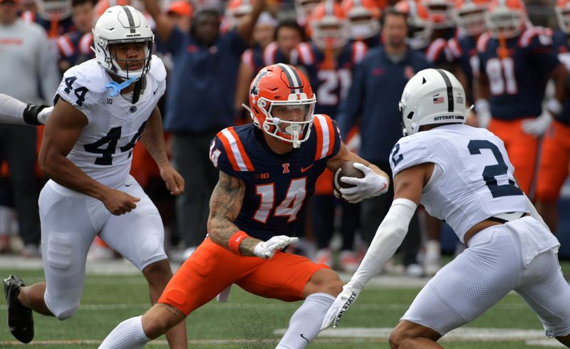 Sep 16, 2023; Champaign, Illinois, USA;  Illinois Fighting Illini wide receiver Casey Washington (14) runs the ball against Penn State Nittany Lions safety Keaton Ellis (2) during the first half at Memorial Stadium. Mandatory Credit: Ron Johnson-USA TODAY Sports