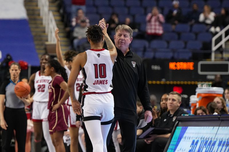 Mar 9, 2024; Greensboro, NC, USA; NC State Wolfpack guard Aziaha James (10) is greeted by head coach Wes Moore during the second half at Greensboro Coliseum. Mandatory Credit: David Yeazell-USA TODAY Sports