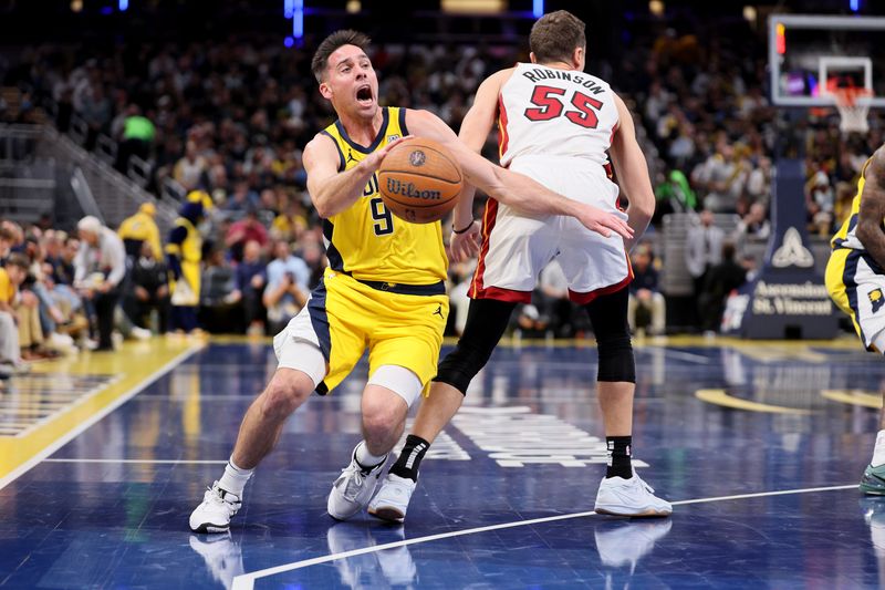 INDIANAPOLIS, INDIANA - NOVEMBER 15: T.J. McConnell #9 of Indiana Pacers is fouled by Duncan Robinson #55 of the Miami Heat at Gainbridge Fieldhouse on November 15, 2024 in Indianapolis, Indiana.  NOTE TO USER: User expressly acknowledges and agrees that, by downloading and or using this photograph, User is consenting to the terms and conditions of the Getty Images License Agreement. (Photo by Andy Lyons/Getty Images)