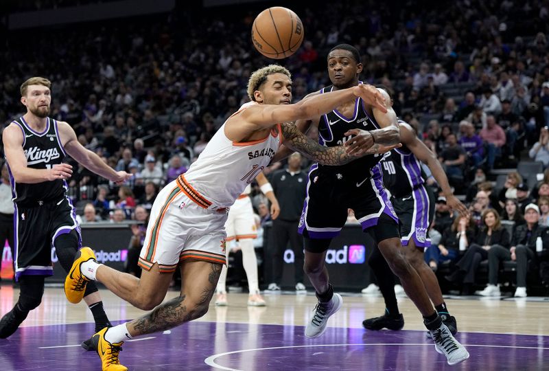 SACRAMENTO, CALIFORNIA - MARCH 07: De'Aaron Fox #5 of the Sacramento Kings and Jeremy Sochan #10 of the San Antonio Spurs battle for a loose ball during the first half at Golden 1 Center on March 07, 2024 in Sacramento, California. NOTE TO USER: User expressly acknowledges and agrees that, by downloading and or using this photograph, User is consenting to the terms and conditions of the Getty Images License Agreement. (Photo by Thearon W. Henderson/Getty Images)