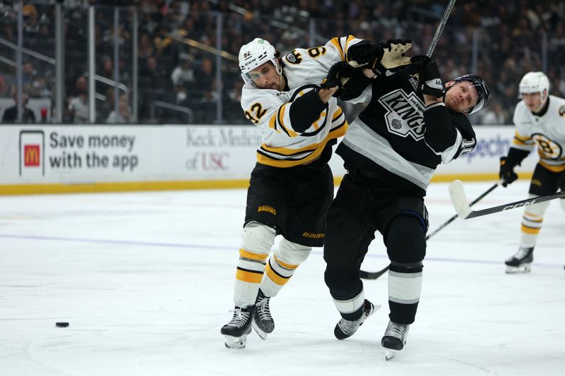 Nov 21, 2025; Los Angeles, California, USA;  Boston Bruins center Marat Khusnutdinov (92) and Los Angeles Kings right wing Corey Perry (10) fight for the puck during the second period at Crypto.com Arena. Mandatory Credit: Kiyoshi Mio-Imagn Images