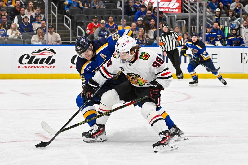 Apr 10, 2024; St. Louis, Missouri, USA;  Chicago Blackhawks center Connor Bedard (98) and St. Louis Blues defenseman Colton Parayko (55) battle for the puck during the first period at Enterprise Center. Mandatory Credit: Jeff Curry-USA TODAY Sports