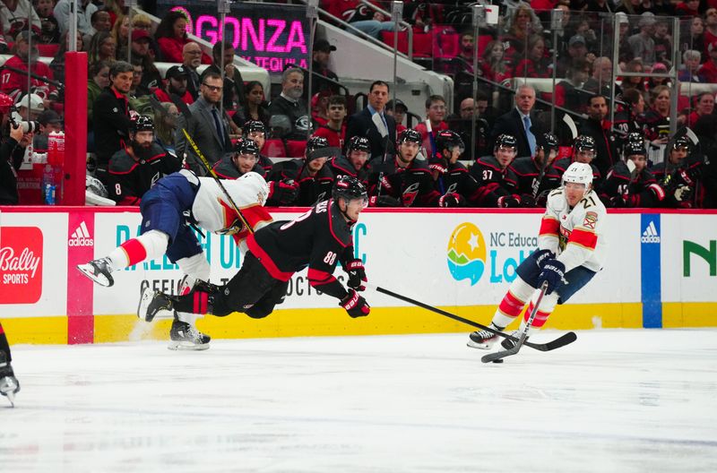 Mar 14, 2024; Raleigh, North Carolina, USA; Florida Panthers right wing Kyle Okposo (8) checks Carolina Hurricanes center Martin Necas (88) during the second period at PNC Arena. Mandatory Credit: James Guillory-USA TODAY Sports