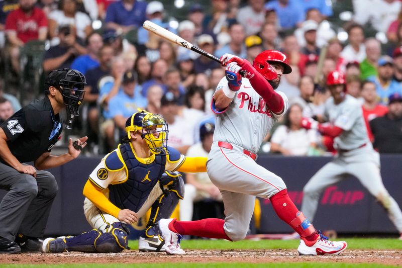 Sep 17, 2024; Milwaukee, Wisconsin, USA;  Philadelphia Phillies designated hitter Kyle Schwarber (12) hits an RBI single during the seventh inning against the Milwaukee Brewers at American Family Field. Mandatory Credit: Jeff Hanisch-Imagn Images