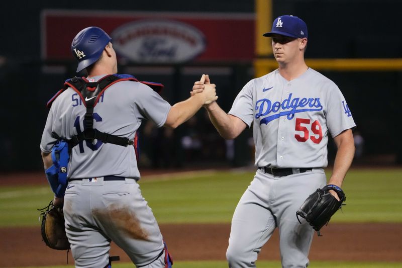 Aug 8, 2023; Phoenix, Arizona, USA; Los Angeles Dodgers relief pitcher Evan Phillips (59) and Los Angeles Dodgers catcher Will Smith (16) shake hands after defeating the Arizona Diamondbacks at Chase Field. Mandatory Credit: Joe Camporeale-USA TODAY Sports