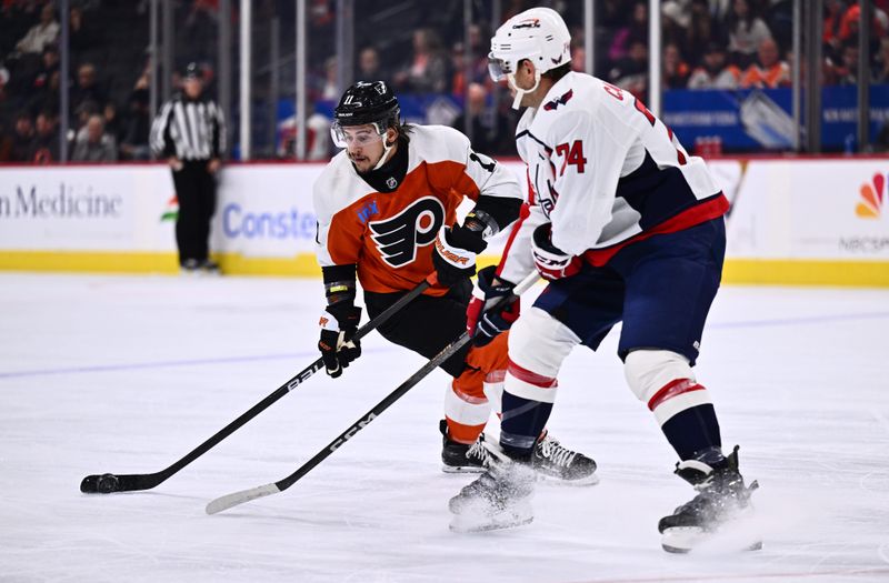 Dec 14, 2023; Philadelphia, Pennsylvania, USA; Philadelphia Flyers right wing Travis Konecny (11) controls the puck against Washington Capitals defenseman John Carlson (74) in the first period at Wells Fargo Center. Mandatory Credit: Kyle Ross-USA TODAY Sports