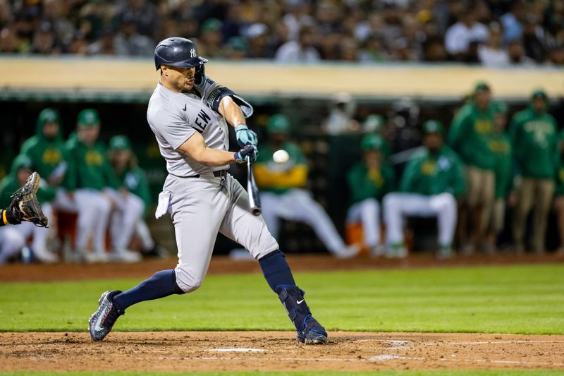 Sep 20, 2024; Oakland, California, USA; New York Yankees designated hitter Giancarlo Stanton (27) singles during the seventh inning against the New York Yankees at Oakland-Alameda County Coliseum. Mandatory Credit: Bob Kupbens-Imagn Images
