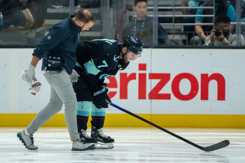 Nov 14, 2024; Seattle, Washington, USA;  Seattle Kraken forward Jordan Eberle (7) is helped from the ice by a trainer during the second period against the Chicago Blackhawks at Climate Pledge Arena. Mandatory Credit: Stephen Brashear-Imagn Images