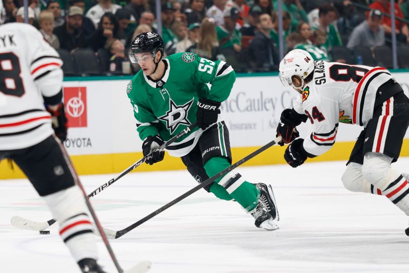 Dec 27, 2025; Dallas, Texas, USA;  Dallas Stars center Wyatt Johnston (53) skates with the puck as Chicago Blackhawks left wing Landon Slaggert (84) defends during the second period at American Airlines Center. Mandatory Credit: Chris Jones-Imagn Images