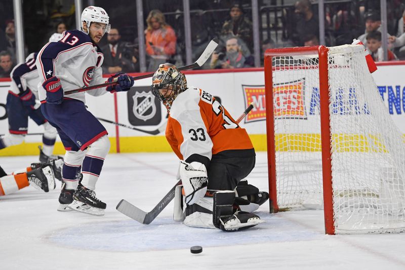 Jan 4, 2024; Philadelphia, Pennsylvania, USA; Philadelphia Flyers goaltender Samuel Ersson (33) makes a save as Columbus Blue Jackets left wing Johnny Gaudreau (13) looks on during the second period at Wells Fargo Center. Mandatory Credit: Eric Hartline-USA TODAY Sports