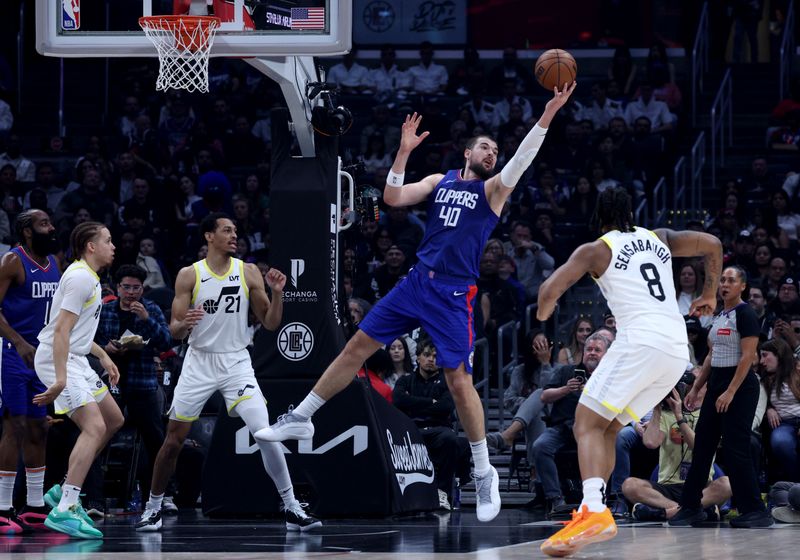 LOS ANGELES, CALIFORNIA - APRIL 12: Ivica Zubac #40 of the LA Clippers reaches for a rebound between Brice Sensabaugh #8, Darius Bazley #21 and Jason Preston #10 during a 110-109 loss to the Utah Jazz at Crypto.com Arena on April 12, 2024 in Los Angeles, California. User is consenting to the terms and conditions of the Getty Images License Agreement.  (Photo by Harry How/Getty Images)