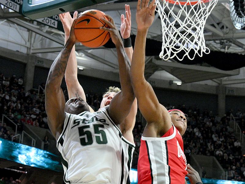 Feb 22, 2026; East Lansing, Michigan, USA;  Michigan State Spartans forward Coen Carr (55) comes down with a rebound against the Ohio State Buckeyes during the first half at Jack Breslin Student Events Center. Mandatory Credit: Dale Young-Imagn Images