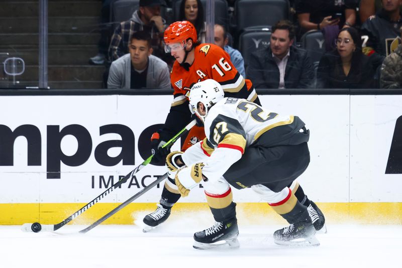 Nov 13, 2024; Anaheim, California, USA; Vegas Golden Knights defenseman Shea Theodore (27) and Anaheim Ducks center Ryan Strome (16) battle for the puck during the second period of a hockey game at Honda Center. Mandatory Credit: Jessica Alcheh-Imagn Images