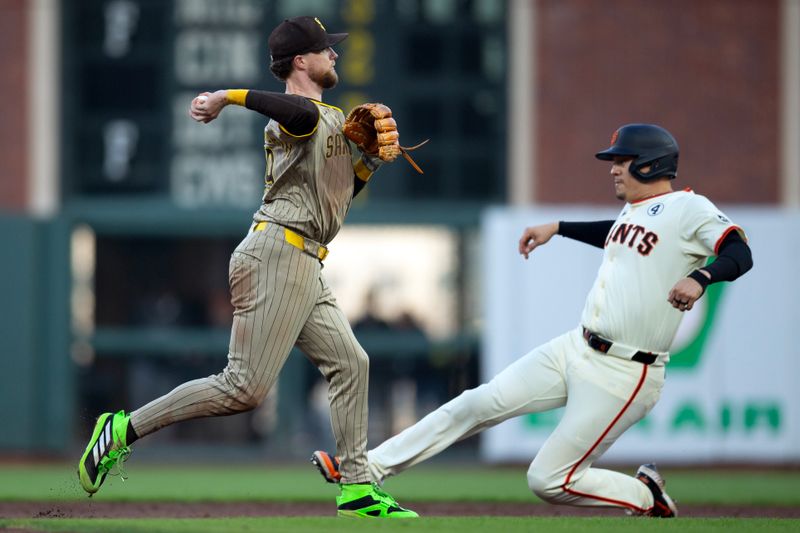 Jun 2, 2025; San Francisco, California, USA; San Diego Padres second baseman Jake Cronenworth (9) throws over San Francisco Giants designated hitter Wilmer Flores (41) to complete a double play during the third inning at Oracle Park. Mandatory Credit: D. Ross Cameron-Imagn Images