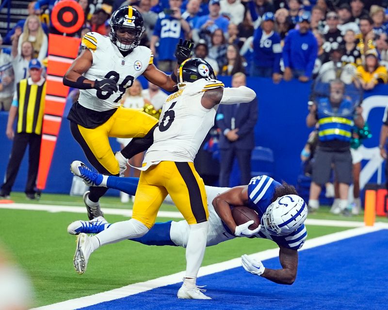 Indianapolis Colts tight end Drew Ogletree (85) falls into the end zone for a touchdown with Pittsburgh Steelers linebacker Patrick Queen (6) and Minkah Fitzpatrick (39) defending during the second half of an NFL football game Sunday, Sept. 29, 2024, in Indianapolis. (AP Photo/Darron Cummings)