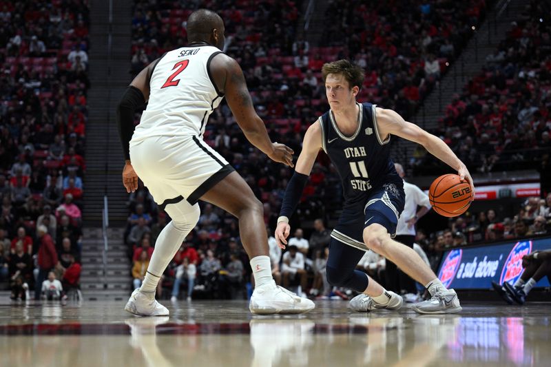 Jan 25, 2023; San Diego, California, USA; Utah State Aggies guard Max Shulga (11) dribbles the ball while defended by San Diego State Aztecs guard Adam Seiko (2) during the second half at Viejas Arena. Mandatory Credit: Orlando Ramirez-USA TODAY Sports