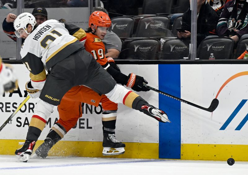 Dec 4, 2024; Anaheim, California, USA;  Vegas Golden Knights center Brett Howden (21) checks Anaheim Ducks right wing Troy Terry (19) into the boards during the second period at Honda Center. Mandatory Credit: Alex Gallardo-Imagn Images