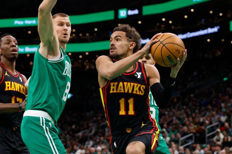 BOSTON, MA - FEBRUARY 7: Trae Young #11 of the Atlanta Hawks drives on Kristaps Porzingis #8 of the Boston Celtics during the first quarter at TD Garden on February 7, 2024 in Boston, Massachusetts. NOTE TO USER: User expressly acknowledges and agrees that, by downloading and/or using this Photograph, user is consenting to the terms and conditions of the Getty Images License Agreement. (Photo By Winslow Townson/Getty Images)