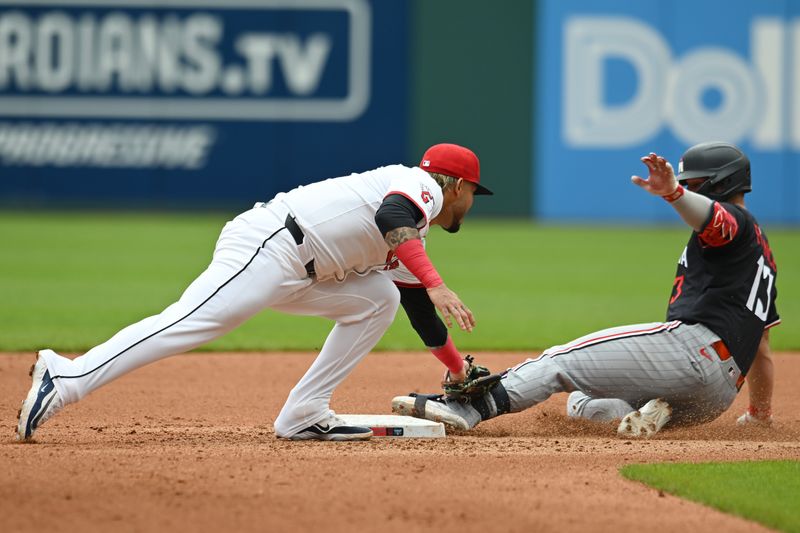 May 1, 2025; Cleveland, Ohio, USA; Minnesota Twins first baseman Ty France (13) slides into second with a double as Cleveland Guardians second baseman Gabriel Arias (13) is late wit the tag during the fourth inning at Progressive Field. Mandatory Credit: Ken Blaze-Imagn Images

