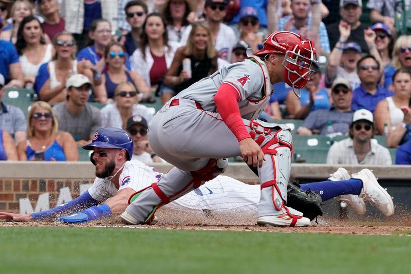 Jul 7, 2024; Chicago, Illinois, USA; Chicago Cubs third baseman Miles Mastrobuoni (20) is safe at home plate as Los Angeles Angels catcher Logan O'Hoppe (14) makes a late tag during the third inning at Wrigley Field. Mandatory Credit: David Banks-USA TODAY Sports