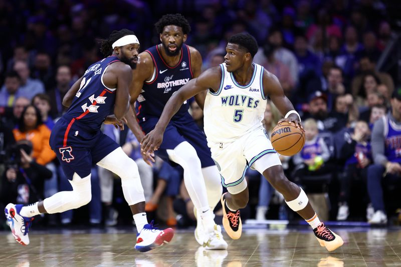 PHILADELPHIA, PENNSYLVANIA - DECEMBER 20: Anthony Edwards #5 of the Minnesota Timberwolves dribbles by Patrick Beverley #22 and Joel Embiid #21 of the Philadelphia 76ers during the first quarter at the Wells Fargo Center on December 20, 2023 in Philadelphia, Pennsylvania. NOTE TO USER: User expressly acknowledges and agrees that, by downloading and or using this photograph, User is consenting to the terms and conditions of the Getty Images License Agreement. (Photo by Tim Nwachukwu/Getty Images)