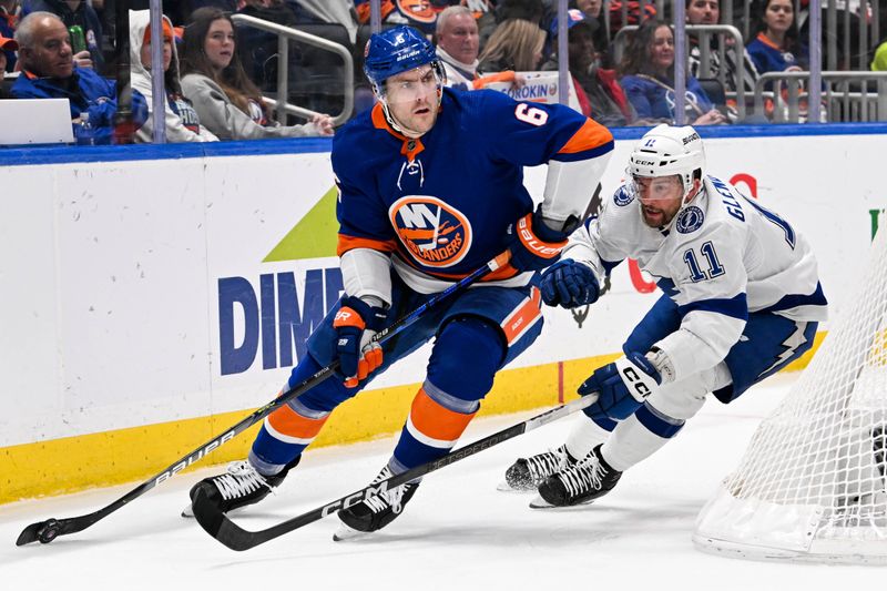 Feb 8, 2024; Elmont, New York, USA; New York Islanders defenseman Ryan Pulock (6) skates the puck out from behind the net chased by Tampa Bay Lightning center Luke Glendening (11) during the third period at UBS Arena. Mandatory Credit: Dennis Schneidler-USA TODAY Sports