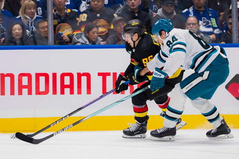 Dec 23, 2023; Vancouver, British Columbia, CAN; Vancouver Canucks forward Andrei Kuzmenko (96) drives past San Jose Sharks defenseman Jan Rutta (84) in the third period at Rogers Arena. Canucks won 7-4. Mandatory Credit: Bob Frid-USA TODAY Sports