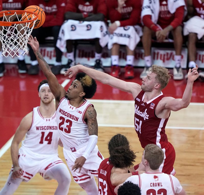 Jan 6, 2024; Madison, Wisconsin, USA; Wisconsin guard Chucky Hepburn (23) drives past Nebraska forward Rienk Mast (51) to score during the first half at Kohl Center. Mandatory Credit: Mark Hoffman-USA TODAY Sports