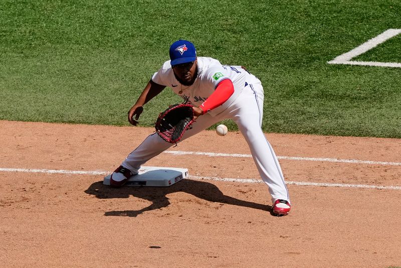 Jul 28, 2024; Toronto, Ontario, CAN; Toronto Blue Jays first baseman Vladimir Guerrero Jr. (27) gets Texas Rangers second baseman Marcus Semien (not pictured) out at first base during the seventh inning at Rogers Centre. Mandatory Credit: John E. Sokolowski-USA TODAY Sports