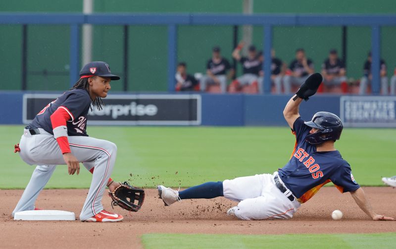 Mar 18, 2024; West Palm Beach, Florida, USA; Houston Astros second baseman Jose Altuve (27) slides safely into second as Washington Nationals short stop C.J. Abrams  waits on the ball during the first inning at The Ballpark of the Palm Beaches. Mandatory Credit: Reinhold Matay-USA TODAY Sports