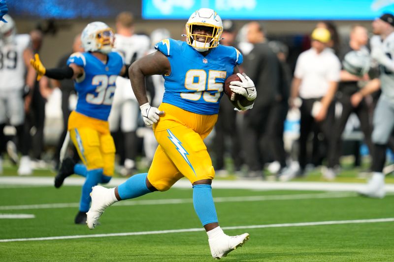 Los Angeles Chargers defensive tackle Poona Ford (95) celebrates after an interception against the Las Vegas Raiders during the second half of an NFL football game, Sunday, Sept. 8, 2024, in Inglewood, Calif. (AP Photo/Ashley Landis)