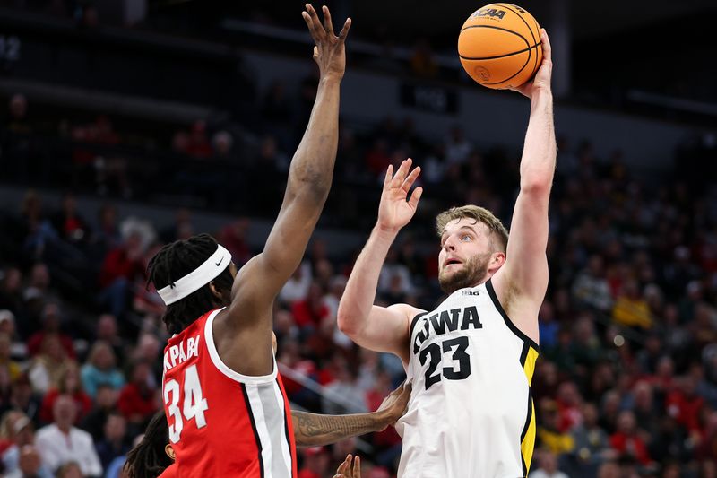 Mar 14, 2024; Minneapolis, MN, USA; Iowa Hawkeyes forward Ben Krikke (23) shoots as Ohio State Buckeyes center Felix Okpara (34) defends during the first half at Target Center. Mandatory Credit: Matt Krohn-USA TODAY Sports