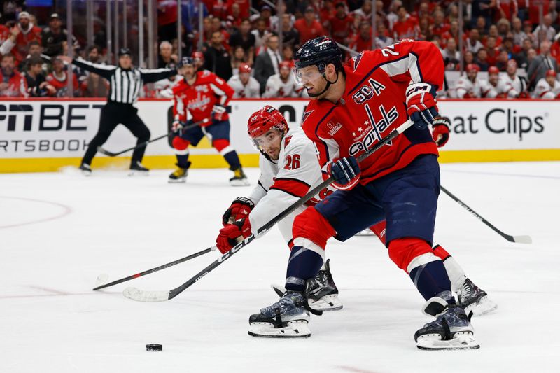 May 15, 2025; Washington, District of Columbia, USA; Washington Capitals defenseman John Carlson (74) skates with the puck on goal as Carolina Hurricanes defenseman Sean Walker (26) defends in the third period in game five of the second round of the 2025 Stanley Cup Playoffs at Capital One Arena. Mandatory Credit: Geoff Burke-Imagn Images