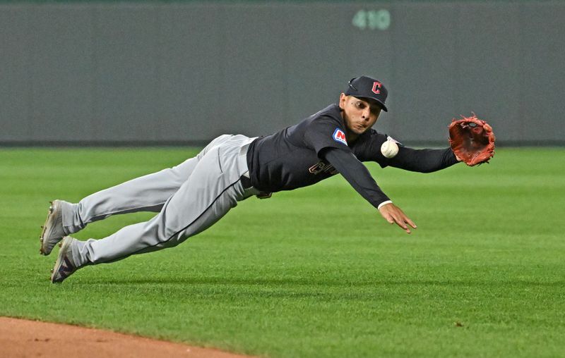 Jun 27, 2024; Kansas City, Missouri, USA;  Cleveland Guardians second baseman Andres Gimenez (0) makes a diving play on a ground ball in the ninth inning against the Kansas City Royals at Kauffman Stadium. Mandatory Credit: Peter Aiken-USA TODAY Sports