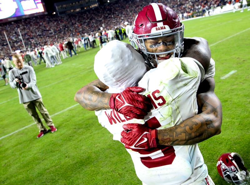 Nov 25, 2023; Auburn, Alabama, USA;  Alabama Crimson Tide defensive back Malachi Moore (13) and running back Roydell Williams (5) celebrate after a last-second victory against the Auburn Tigers at Jordan-Hare Stadium. Alabama won 27-24. Mandatory Credit: Gary Cosby Jr.-USA TODAY Sports