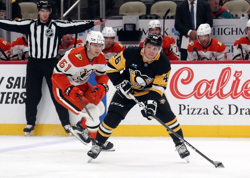 Oct 31, 2024; Pittsburgh, Pennsylvania, USA;  Pittsburgh Penguins center Blake Lizotte (46) moves the puck against  Anaheim Ducks left wing Cutter Gauthier (61) during the first period at PPG Paints Arena. Mandatory Credit: Charles LeClaire-Imagn Images