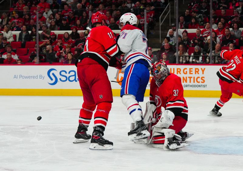 Dec 28, 2023; Raleigh, North Carolina, USA; Carolina Hurricanes goaltender Antti Raanta (32) and center Jordan Staal (11) stops the shot against Montreal Canadiens center Jake Evans (71) during the second period at PNC Arena. Mandatory Credit: James Guillory-USA TODAY Sports